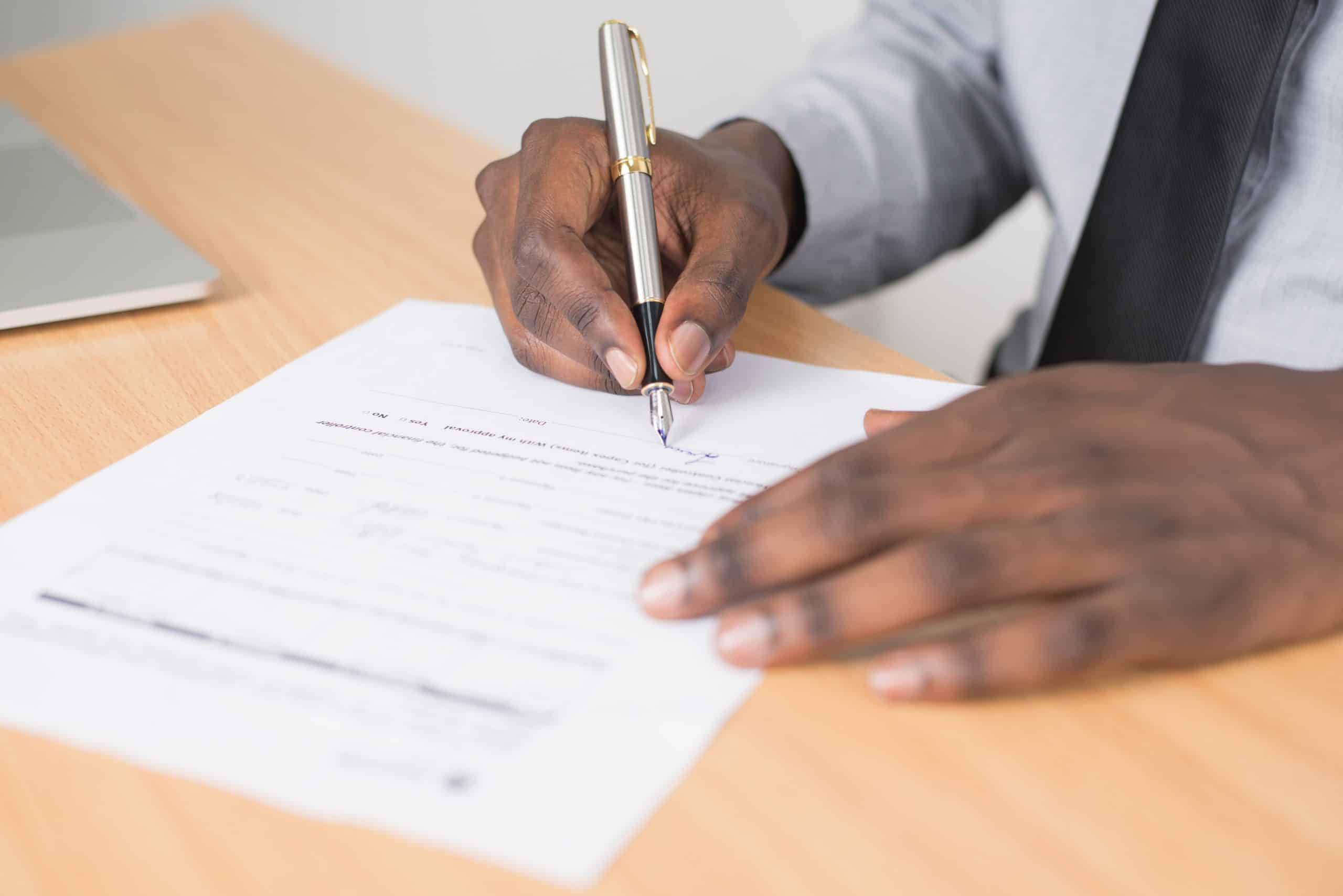 close up of hands signing a document