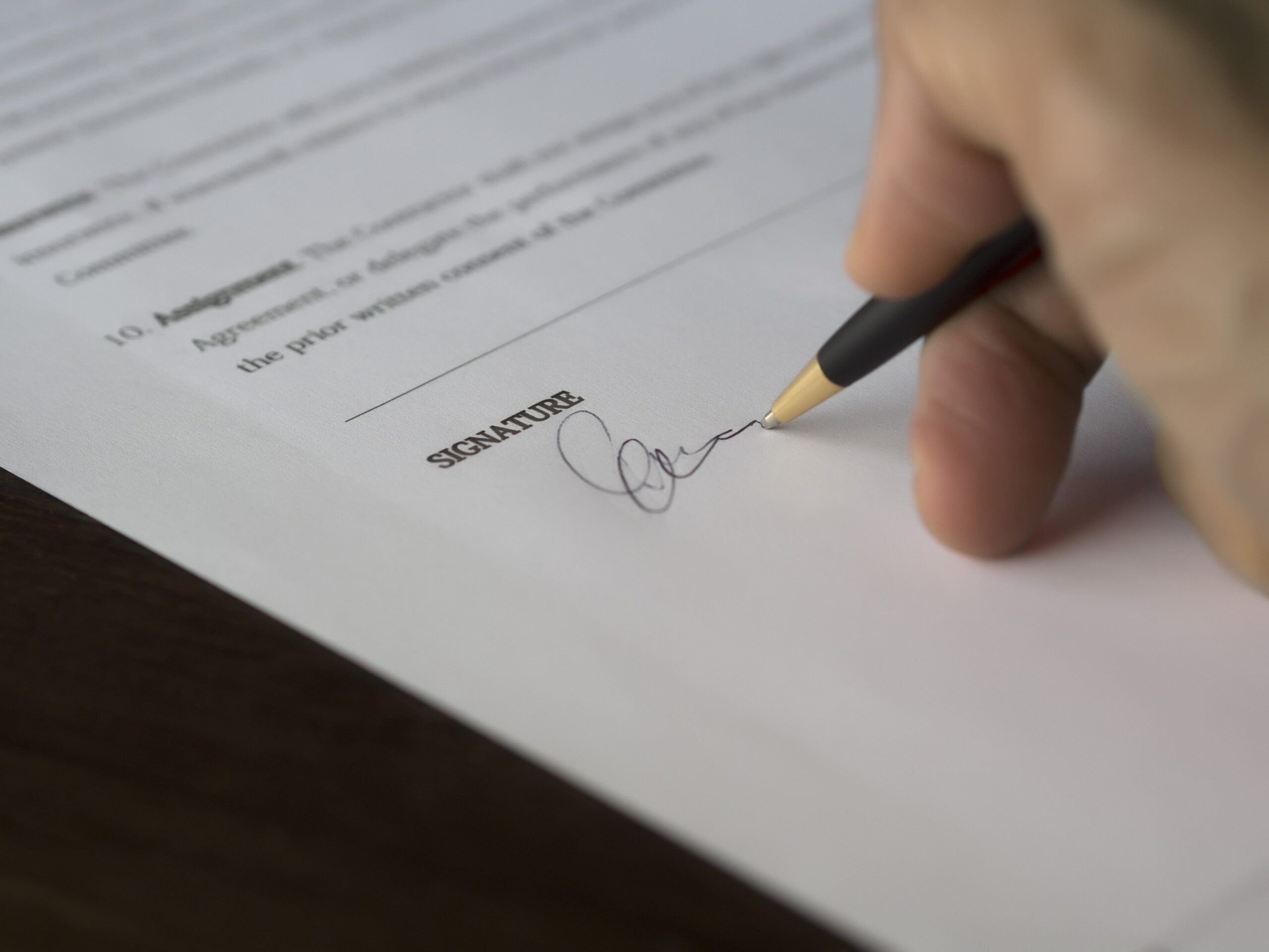 a person signing their signature on a document